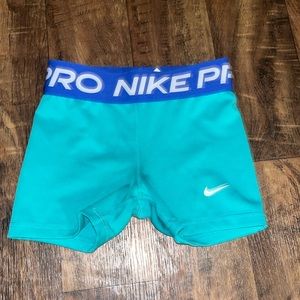 Teal and navy blue Nike pros